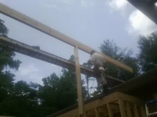 Carpenter setting a ridge beam over a new addition frame — Ice Dam Removal by Roofing Brothers in Playa Del Rey